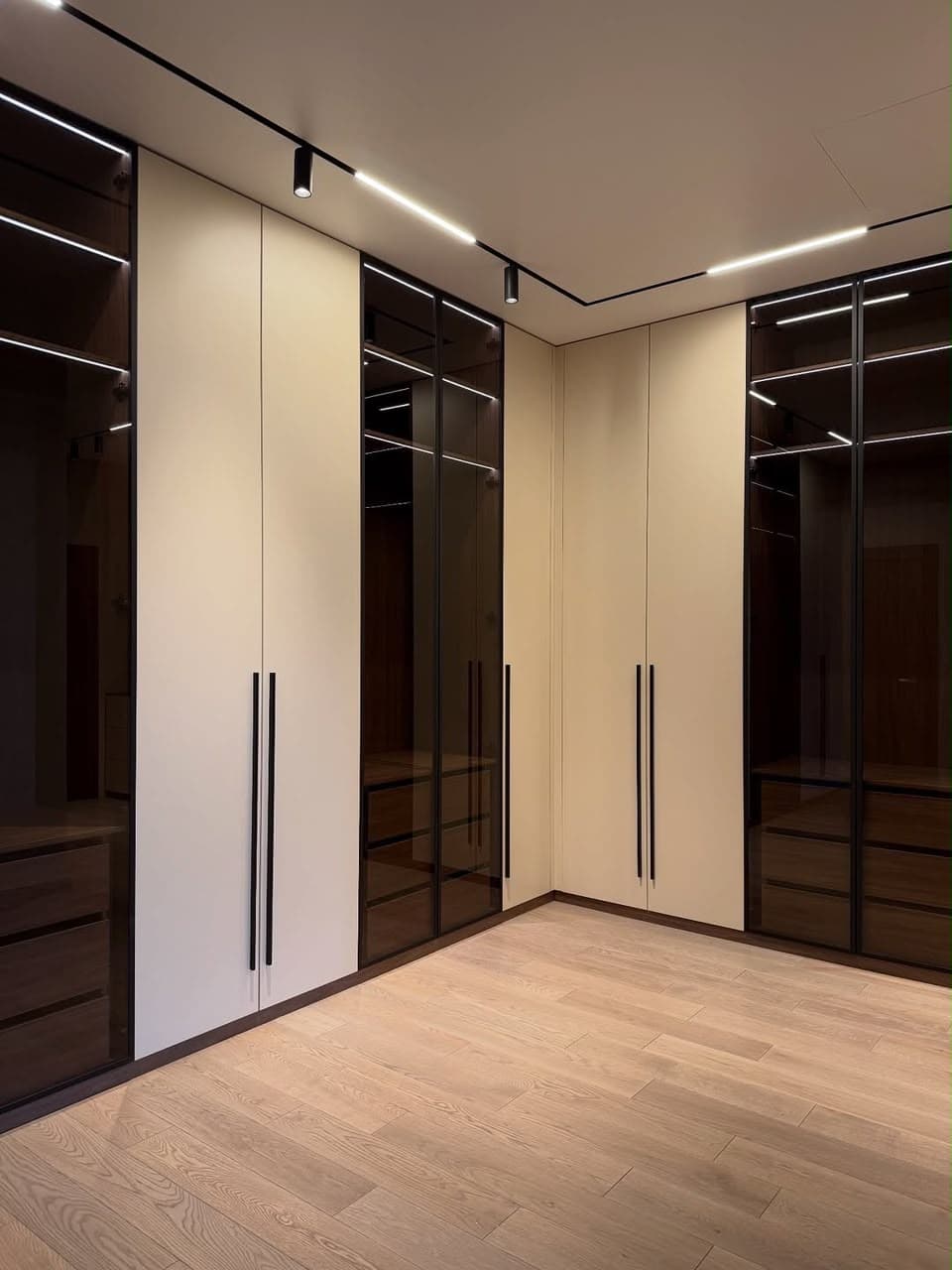 Corner wardrobe with smoked glass doors and long black handles