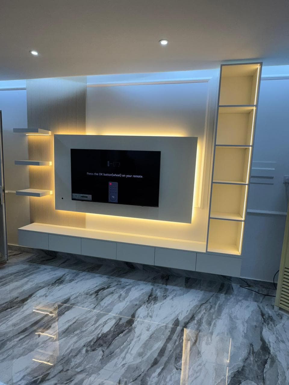 Custom joinery TV media wall with backlit display shelving